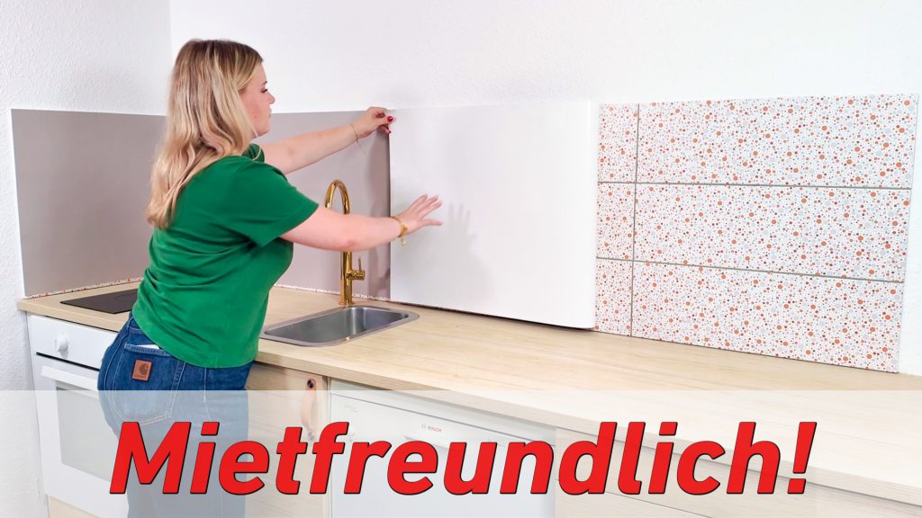 Frau zieht selbstklebende Küchenrückwand von Fliesenspiegel ab