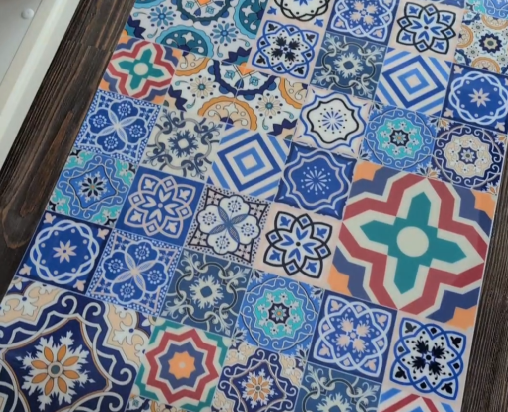 Küchenrückwand mit quadratischen Fliesen in verschiedenen Mustern und Farben, darunter geometrische und florale Motive