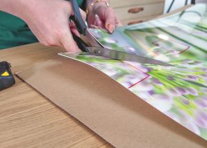 Das Kuechenrueckwand Premium Material wird mit einer Schere geschnitten